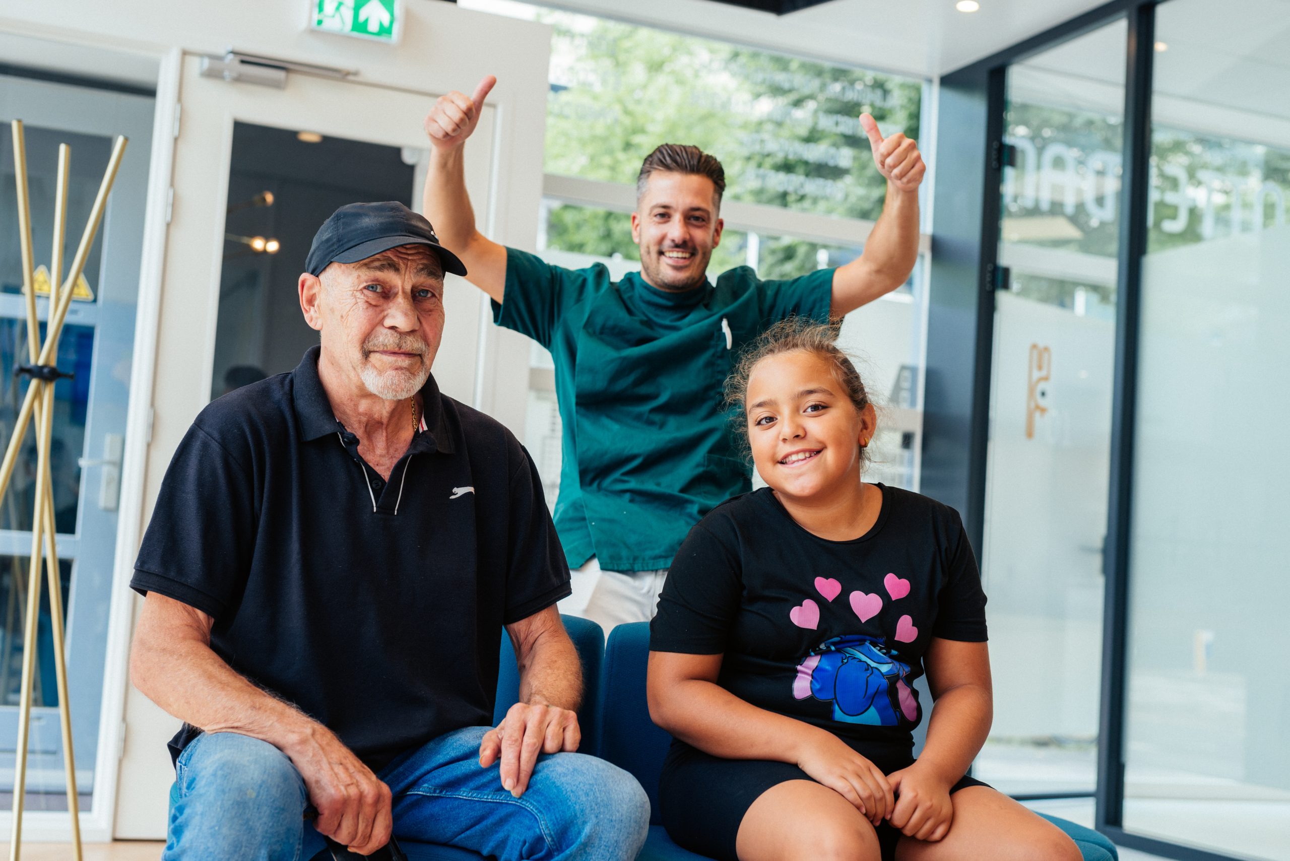 Een van onze tandartsen op de foto met twee patiënten in onze wachtkamer